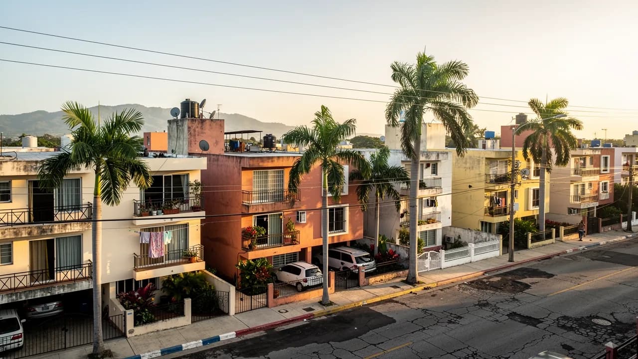 Vista panorámica del sector Jardines del Sur en Santiago de los Caballeros, mostrando edificios residenciales de mediana altura con fachadas modernas y vegetación tropical